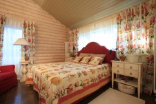 Фото интерьера спальни гостевого дома из оцилиндрованного бревна