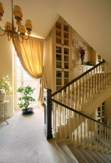Фото интерьера лестницы трехэтажного загородного дома в классическом стиле